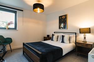 a bedroom with a bed and a window at City View - A Stunning 2 Bed Apartment in Glasgow