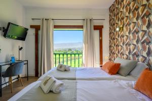 a bedroom with a bed and a large window at Bandama Golf Hotel in Santa Brígida