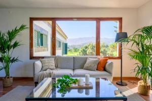 a living room with a couch and a large window at Bandama Golf Hotel by Airnest in Santa Brígida