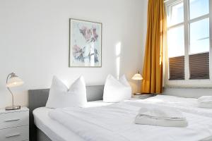 2 weiße Betten in einem Zimmer mit 2 Fenstern in der Unterkunft Hamburg App. 07 in Ahlbeck