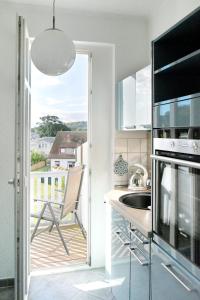 a kitchen with a view of a balcony at Hamburg-App-07 in Ahlbeck
