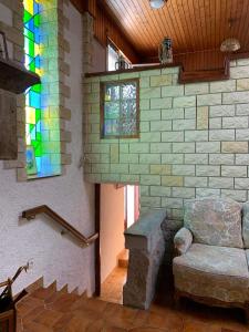 a room with a chair and a stained glass window at Maison de vacances 
