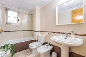 a bathroom with a sink and a toilet and a mirror at 090 Apartamento Imperial in Torrevieja