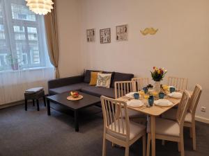 Little Tom Apartments في براغ: غرفة معيشة مع طاولة وأريكة