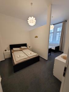 Little Tom Apartments في براغ: غرفة نوم بسرير وثريا