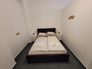 Little Tom Apartments في براغ: غرفة نوم بسرير وفوط بيضاء