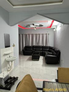 Ifson Home 2 في Kankamsen: غرفة معيشة مع أريكة جلدية سوداء ومغسلة