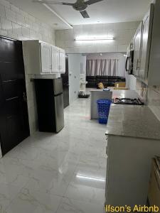 a kitchen with white tile floors and a black refrigerator at Ifson Home 2 in Kankamsen