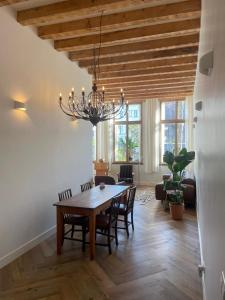 a dining room with a table and a chandelier at 't hart van Schiedam in Schiedam