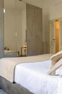 1 dormitorio con 1 cama grande con sábanas blancas en Homelink Firenze - Charlotte, en Florencia