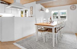 una cucina bianca con tavolo e sedie in legno di 3 Bedroom Nice Home In Aakirkeby a Vester Sømarken