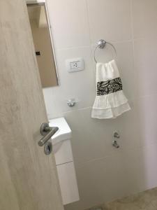 a bathroom with a sink and a mirror and a towel at La Calala Aparts in Esquel