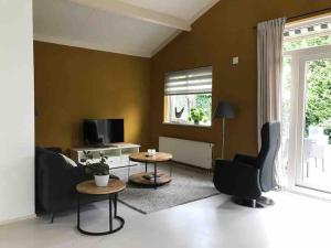 een woonkamer met 2 stoelen en een tafel bij Sfeervol vakantiehuis op de Veluwe 2-6 personen in Putten