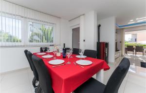 a dining room with a red table and black chairs at Amazing Home In Zaton With Heated Swimming Pool in Zaton