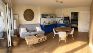 a living room with a couch and a table at * Le Hameau de la plage * in Étables-sur-Mer