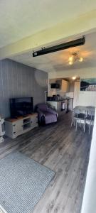 a living room with a table and a dining room at Watkin - Snowdon Cabins Dog friendly holiday let - Caernarfon in Caeathro