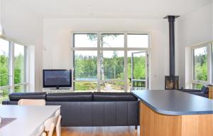 uma sala de estar com um sofá e uma televisão em Beautiful Home In Holmsj With Sauna em Holmsjö