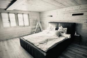 a bedroom with a large bed in a white room at Luxury & Cosy 3.5 rooms apartment in almost 300 years old Chalet in Leukerbad