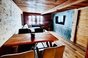 sala de estar con mesa de madera y sofá en Luxury & Cosy 3.5 rooms apartment in almost 300 years old Chalet, en Leukerbad