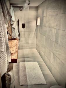 La salle de bains est pourvue d'une douche et d'un tapis. dans l'établissement Luxury & Cosy 3.5 rooms apartment in almost 300 years old Chalet, à Loèche-les-Bains