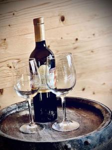 - une bouteille de vin et 2 verres à vin sur une table dans l'établissement Luxury & Cosy 3.5 rooms apartment in almost 300 years old Chalet, à Loèche-les-Bains