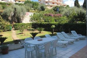 a white table and chairs on a patio at Residence L'uliveto in Gioiosa Marea