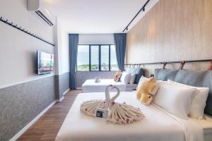ein Hotelzimmer mit 2 Betten und einem Teddybär darauf in der Unterkunft Bagan Suite in Butterworth