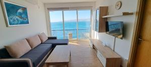 a living room with a couch and a large window at Apartman Helena in Senj