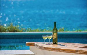 uma garrafa de vinho e dois copos numa mesa em Nice Home In Kosljun With Outdoor Swimming Pool em Košljun