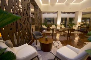 a lobby with white chairs and a table at SUNSOL UNIK Luxury Hotel in Porlamar