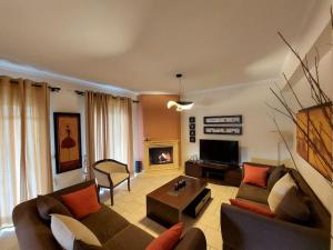 un soggiorno con divano e camino di Heraklia's house a Perama