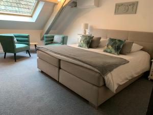 a bedroom with a large bed and two chairs at Hotel SPA Restaurant Au Cheval Blanc in Ribeauvillé