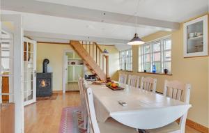 a dining room with a table and a wood stove at Three-Bedroom Holiday Home In Tranekar in Østerhuse