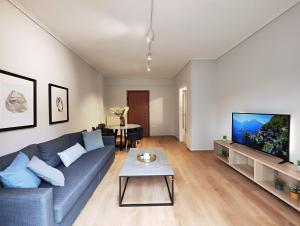 sala de estar con sofá azul y TV en Etolou A2 - by Verde Apartments, en Atenas