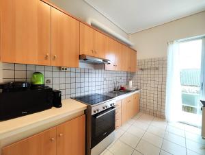 a kitchen with wooden cabinets and a stove top oven at Etolou A2 - by Verde Apartments in Athens