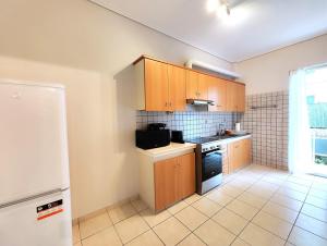 una pequeña cocina con armarios de madera y nevera. en Etolou A2 - by Verde Apartments, en Atenas