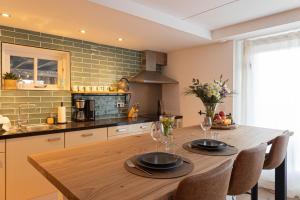 a kitchen with a wooden table with two glasses on it at Casita in Sint Maarten
