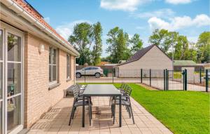 d'une terrasse avec une table et des chaises dans la cour. dans l'établissement Lovely Home In Lombardsijde With Kitchen, à Lombardsijde