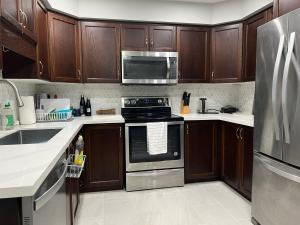 a kitchen with wooden cabinets and stainless steel appliances at Hestia Unit in Kitchener