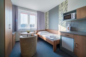 トレボンにあるGarni Hotel Třeboňのベッドとテーブルが備わる小さなホテルルームです。