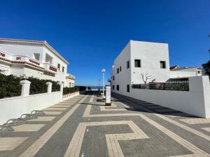 a street with white buildings and a blue sky at Oliva Seaside Apartments in Oliva