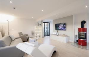 a white living room with a white couch and a fireplace at Garden Suite in Binz
