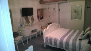 a bedroom with a bed and a desk and mirror at Troy House in Painswick