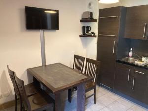 een keuken met een tafel en stoelen in een kamer bij Appartement 2 pièces Résidence les Fermes Emiguy Les Gets in Les Gets