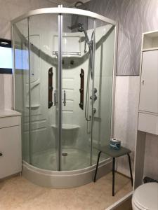um chuveiro com uma caixa de vidro na casa de banho em Une nuit près de l eau em Hallines