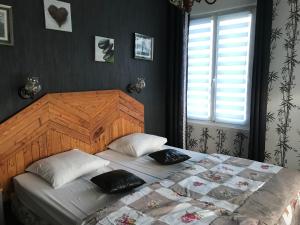 um quarto com uma cama grande e uma cabeceira em madeira em Une nuit près de l eau em Hallines
