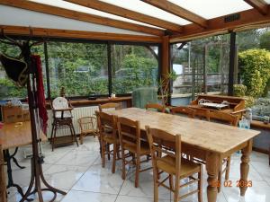 een eetkamer met een houten tafel en stoelen bij Une nuit près de l eau in Hallines