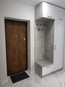 La salle de bains est pourvue d'une porte en bois et d'un placard. dans l'établissement Apartments Domovik Трьохкімнатна квартира , європейського стилю, à Moukatcheve