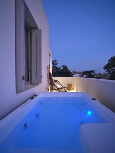 a bath tub with a blue light in a room at Perivoli Luxury Homes, Paros in Dhragoulás