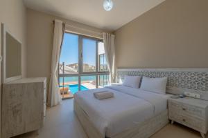 a bedroom with a large bed and a large window at Ascot Bay, Premium 5BR Lagoon Beach House & Pool in Tawila, El Gouna in Hurghada +37 photos